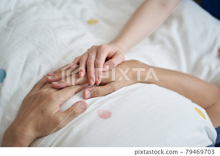 At the hands of an elderly Asian who is seen at the end 79469703