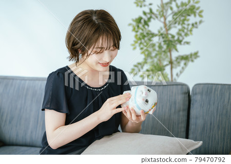 Piggy bank and young lady Piggy bank and young lady 79470792