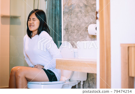 Asian woman suffering with Hemorrhoids or constipation in toilet,Female need to use the toilet in the morning 79474254