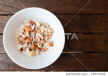 Overhead view of crushed egg shell in bowl. Egg shells are organic fertilizers for gardening rich with calcium and potassium 79474289