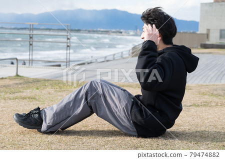 一個男人一邊看海一邊鍛煉腹肌 79474882