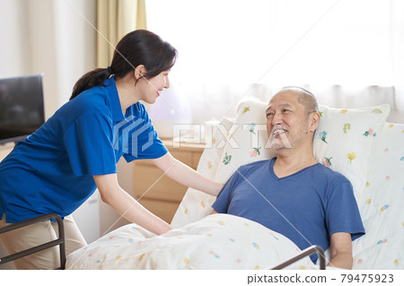 Female caregiver working in a care facility 79475923