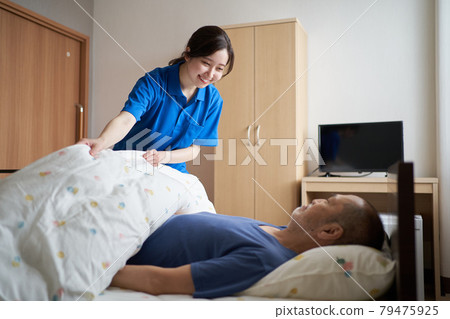 Female caregiver working in a care facility 79475925