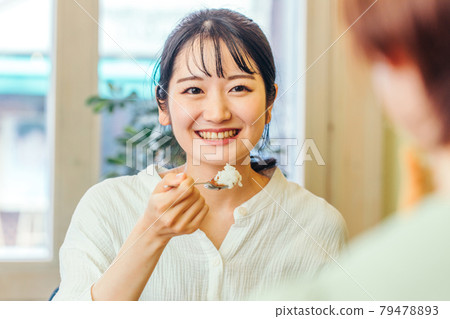 一個女人一邊吃午飯一邊和她的女朋友聊天 一個女人一邊吃午飯一邊和她的女朋友聊天 79478893