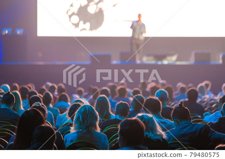 Audience sitting near illuminated stage Audience sitting near illuminated stage 79480575