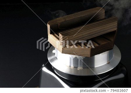 一張黑色背景下在一次性烹飪鍋中煮米飯的照片 79481607