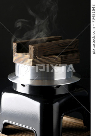 A picture of rice being cooked in a one-go cooking pot on a black background 79481648
