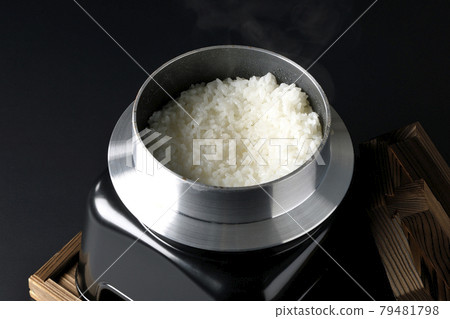 黑色背景中在水壺中煮飯的照片 79481798