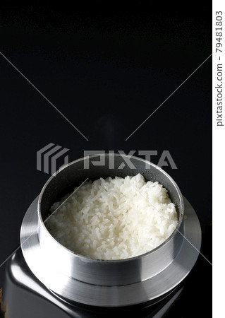 黑色背景中在水壺中煮飯的照片 79481803