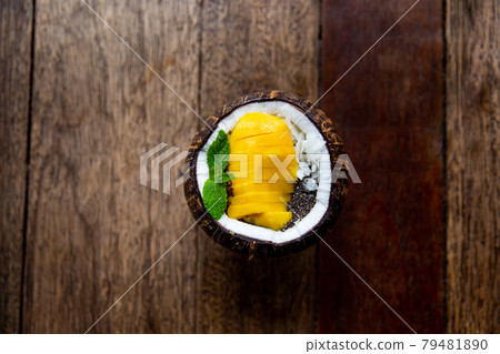 Blue spirrulina smoothie with flakes and chocolate in coconut on rustic background. 79481890