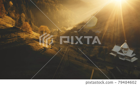 Sunset over fir mountain forest aerial. Autumn nature landscape. Rural cottages at sun mount valley Sunset over fir mountain forest aerial. Autumn nature landscape. Rural cottages at sun mount valley 79484602