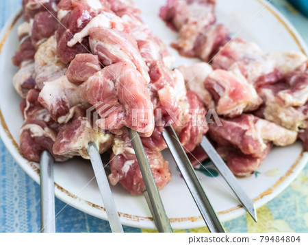 raw skewered shish kebabs from pork meat on plate 79484804