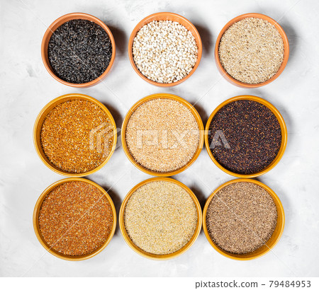 top view of various bird seeds in ceramic bowls 79484953