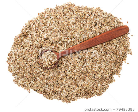 top view of spoon on pile of dill seeds on white 79485393