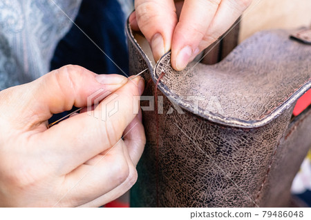 craftsman stitches the side edge of the handbag craftsman stitches the side edge of the handbag 79486048