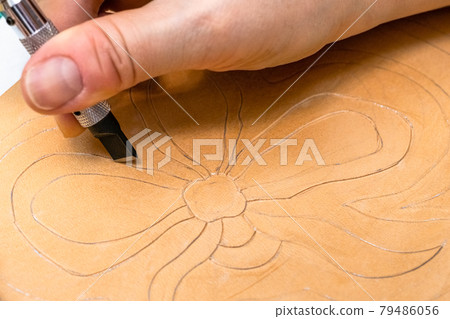 craftsman carves floral pattern on leather craftsman carves floral pattern on leather 79486056