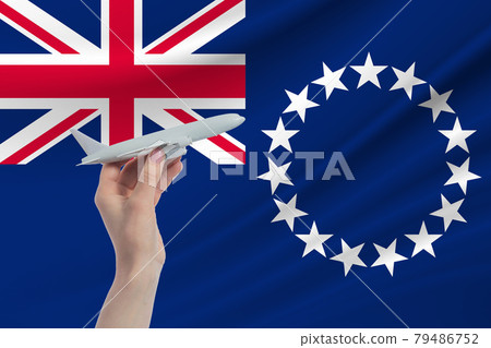 Airplane in hand with national flag of Cook Islands. Travel to Cook Islands Airplane in hand with national flag of Cook Islands. Travel to Cook Islands 79486752