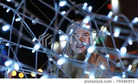 Girl posing against the backdrop of urban Christmas illumination. Girl posing against the backdrop of urban Christmas illumination. 79486955