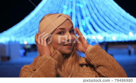 Girl posing against the backdrop of urban Christmas illumination. Girl posing against the backdrop of urban Christmas illumination. 79486980