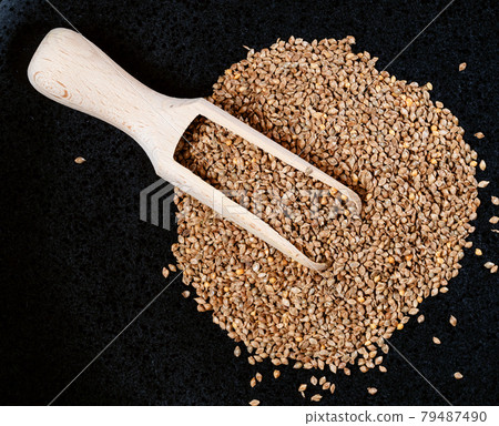 view of scoop on barnyard millet seeds on black view of scoop on barnyard millet seeds on black 79487490
