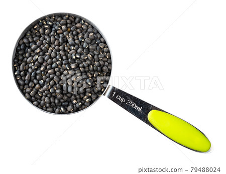 raw whole black urad beans in measuring cup cutout 79488024