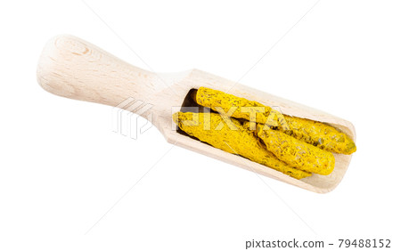 dried roots of Turmeric in wooden scoop cutout 79488152