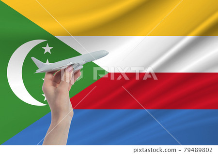Airplane in hand with national flag of Comoros Travel to Comoros 79489802
