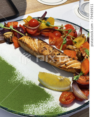 Roasted salmon steak with vegetables garnish Roasted salmon steak with vegetables garnish 79489911