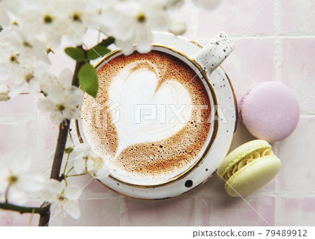 Coffee with a heart-shaped pattern and sweet macaroons desserts Coffee with a heart-shaped pattern and sweet macaroons desserts 79489912