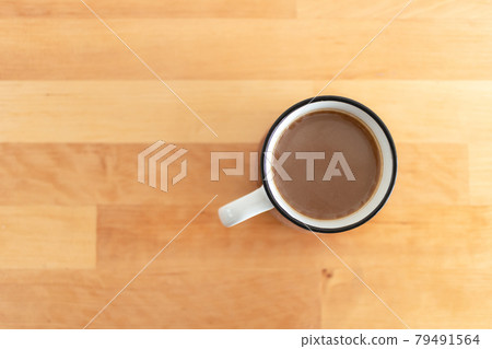 Top view of white cup of hot coffee on table. 79491564