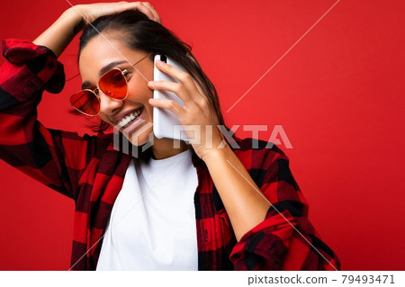 Closeup photo of attractive positive smiling young brunet woman wearing stylish red shirt white t Closeup photo of attractive positive smiling young brunet woman wearing stylish red shirt white t 79493471
