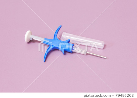 a syringe with a microchip for identifying animals on a pink background, close-up a syringe with a microchip for identifying animals on a pink background, close-up 79495208