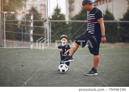 Father with little son playing a football Father with little son playing a football 79496190