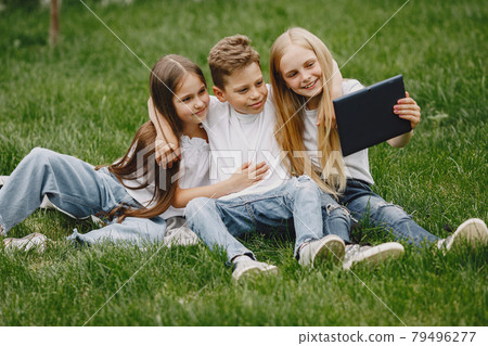 Happy children sitting together close and smile Happy children sitting together close and smile 79496277