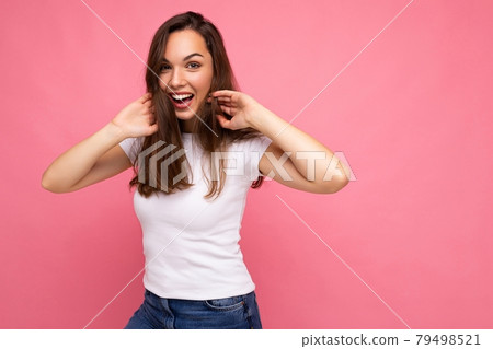 Portrait of positive cheerful fashionable woman in casual white t-shirt for mock up isolated on pink 79498521