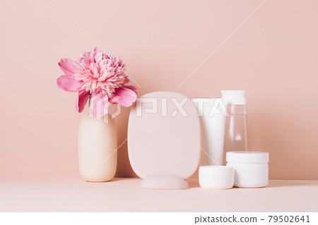 Women's accessories mirror cream oil various cosmetics on a table with flowers. Body and face care health beauty concept 79502641