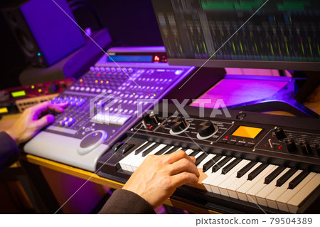 music producer, arranger, DJ hands remixing music on synthesizer keyboard, control surface and computer in home recording studio 79504389