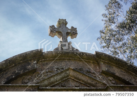 Old carved stone cross of a antique tomb. Galicia, Spain. Low angle. Copy space Old carved stone cross of a antique tomb. Galicia, Spain. Low angle. Copy space 79507350