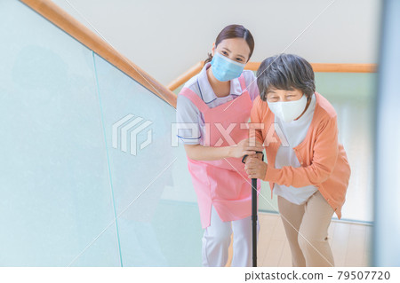 Senior women and care staff on the stairs 79507720