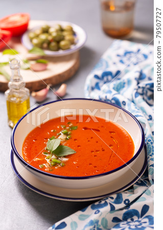 Plate of traditional spanish gazpacho in the background ingredients with white-blue patterned napkin Plate of traditional spanish gazpacho in the background ingredients with white-blue patterned napkin 79507727