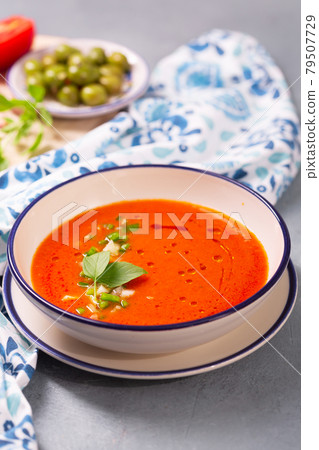Plate of traditional spanish gazpacho in the background ingredients with white-blue patterned napkin Plate of traditional spanish gazpacho in the background ingredients with white-blue patterned napkin 79507729