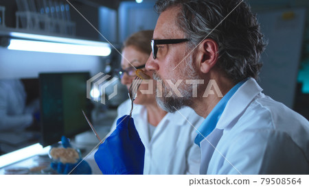 Middle aged colleagues tasting chicken cell meat Middle aged colleagues tasting chicken cell meat 79508564