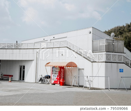 A stand-out vending machine with Coke Ad under the orange umbrella on the side of the shop backyard, Japan. 79509066