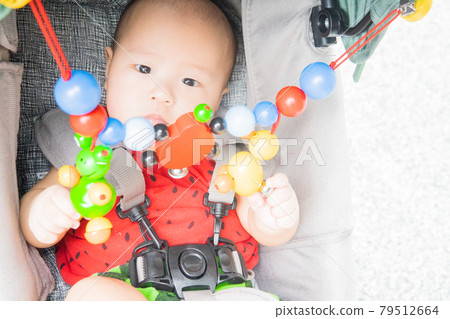 Baby playing with stroller toys 79512664