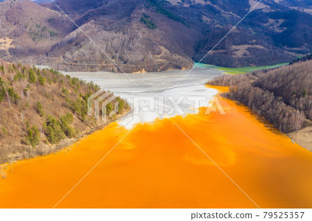 Aerial view of a mining decanting pond with toxic red residuals Aerial view of a mining decanting pond with toxic red residuals 79525357