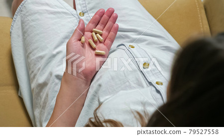 Close-up of a hand pregnant woman holding a capsule Close-up of a hand pregnant woman holding a capsule 79527558