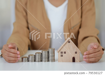 Young active business woman hands in casual dress sitting and protecting house model on white table. Property insurance and security concept 79530127