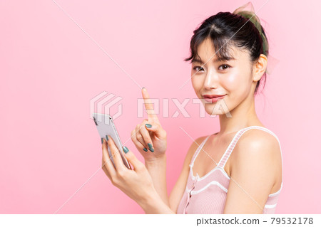 Young woman looking at a smartphone 79532178