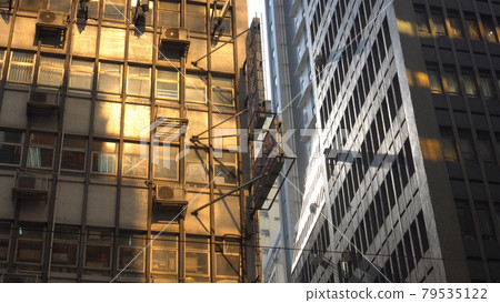 Golden sun reflection through highrise on Hong Kong old residence building cityscape beauty Golden sun reflection through highrise on Hong Kong old residence building cityscape beauty 79535122