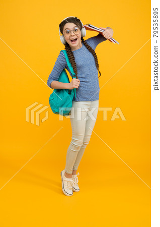 Welcome back to school. Happy child carry backpack yellow background. Welcome back to school. Happy child carry backpack yellow background. 79535895